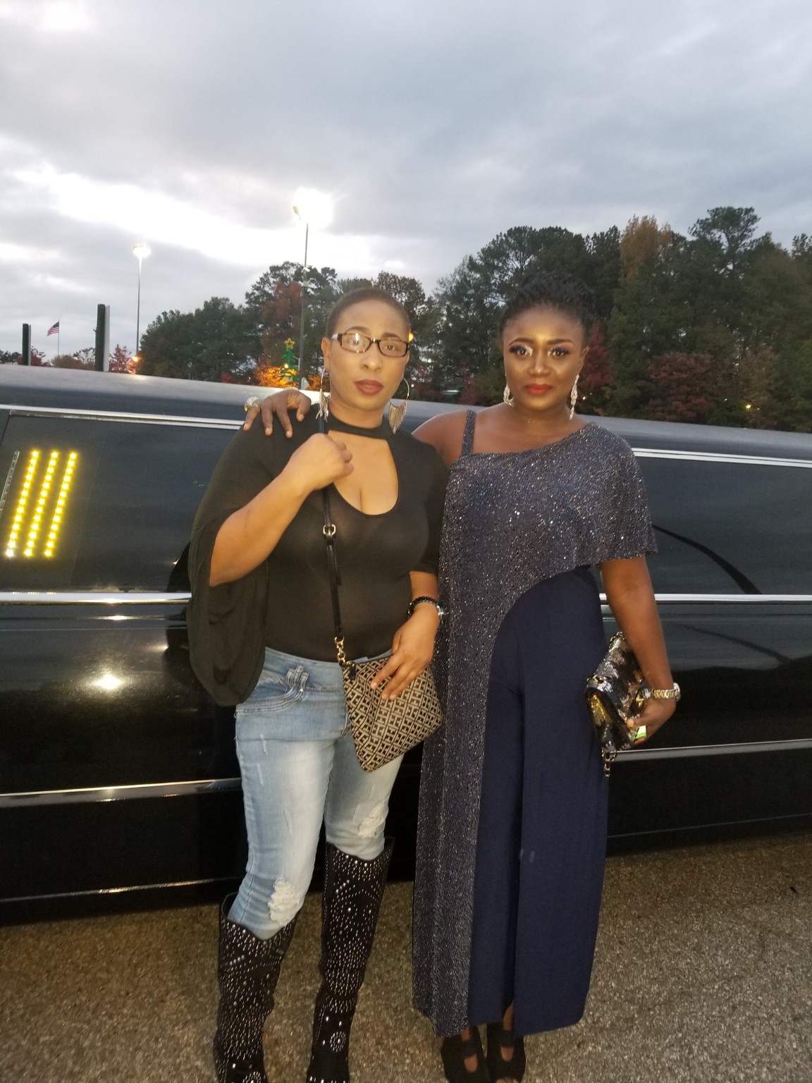 Two guests posing beside a limousine at the movie premiere